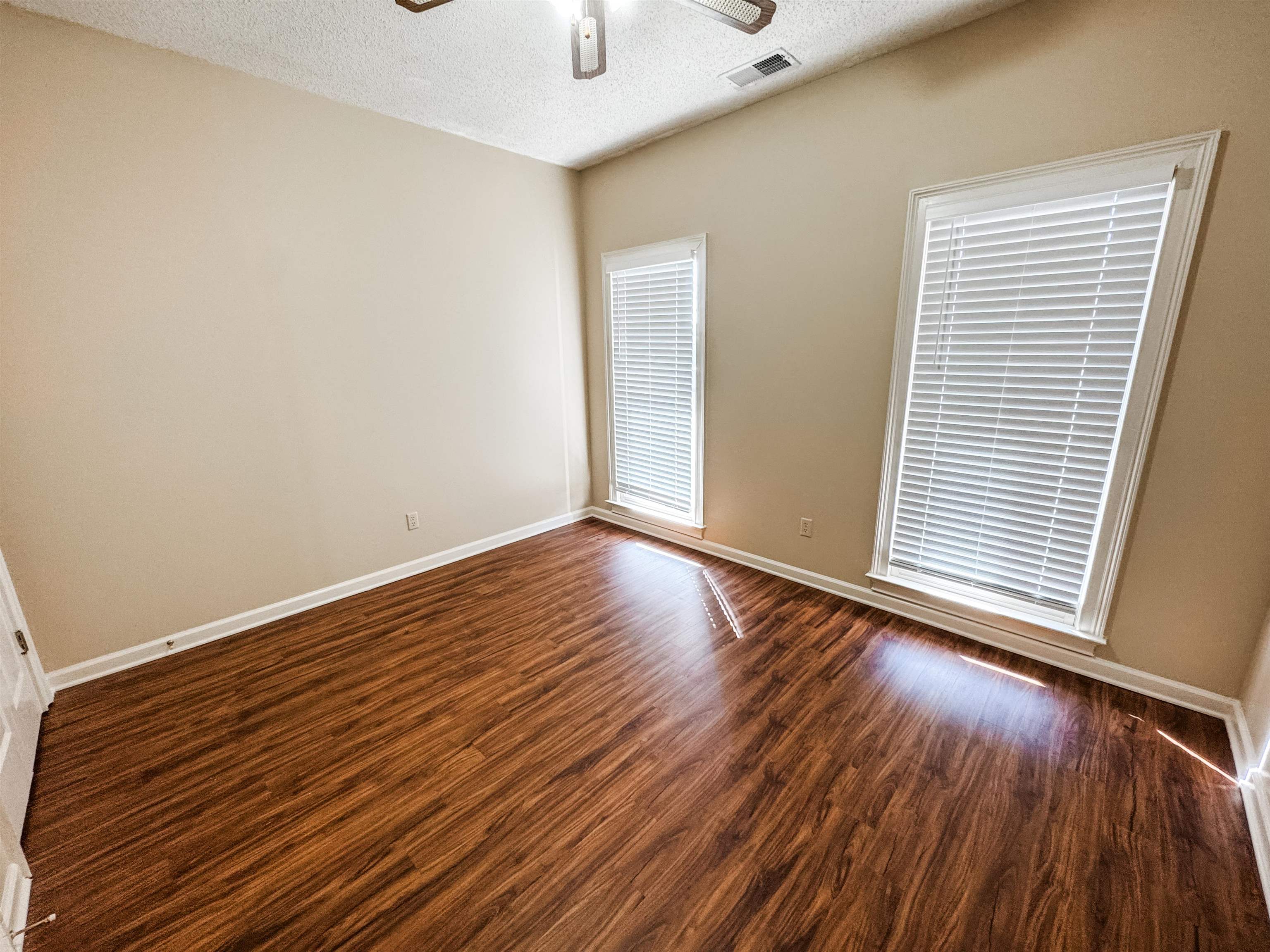 158 Eulas Ridge Cove Collierville, TN 38017 - Photo 14 of 18 Spare room featuring dark wood-style floors, visible vents, baseboards, and ceiling fan