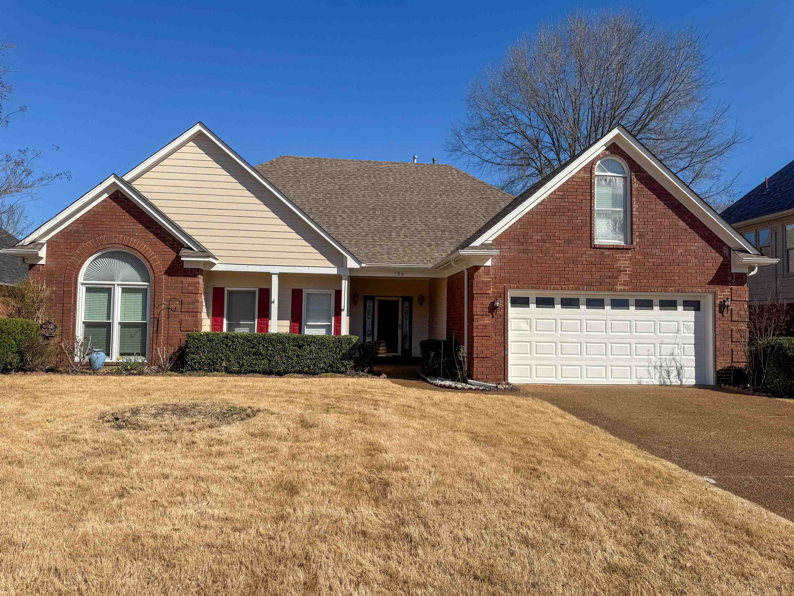 158 Eulas Ridge Cove Collierville, TN 38017 - Photo 2 of 18 View of front of house with driveway, a shingled roof, an attached garage, a front yard, and brick siding