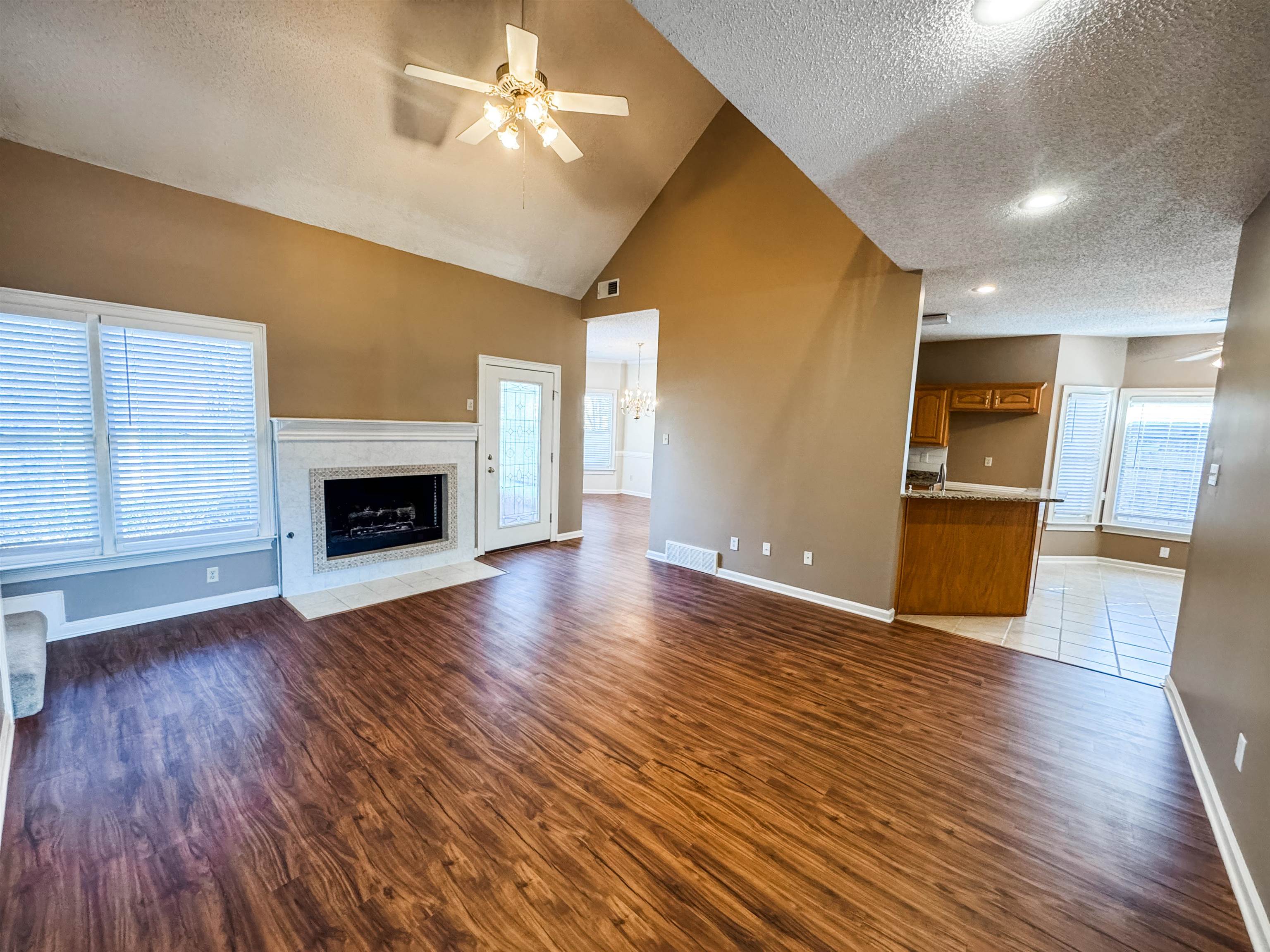 158 Eulas Ridge Cove Collierville, TN 38017 - Photo 3 of 18 Unfurnished living room featuring visible vents, a fireplace with flush hearth, wood finished floors, baseboards, and ceiling fan