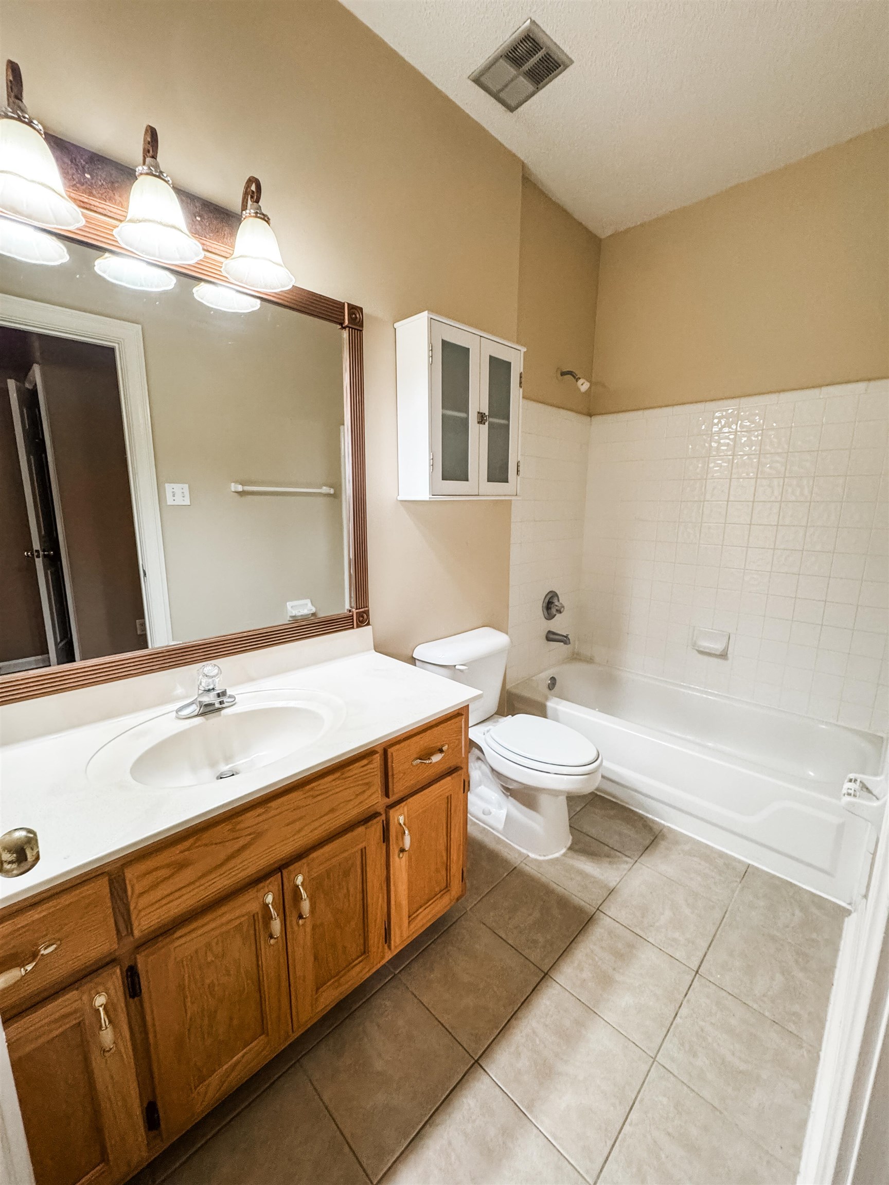 158 Eulas Ridge Cove Collierville, TN 38017 - Photo 9 of 18 Bathroom featuring vanity, washtub / shower combination, visible vents, tile patterned floors, and toilet
