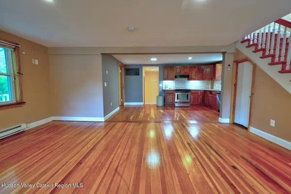a view of a livingroom with wooden floor and furniture
