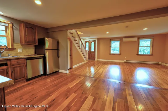 a view of a kitchen with wooden floor and electronic appliances