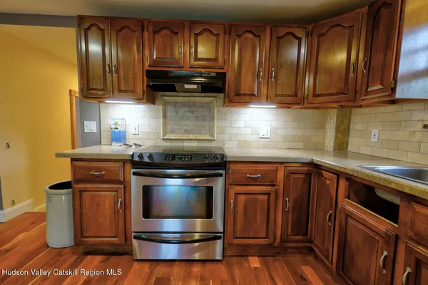 a kitchen with granite countertop wooden cabinets stainless steel appliances and a sink