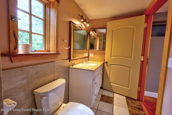 a bathroom with a sink a toilet a mirror and shower