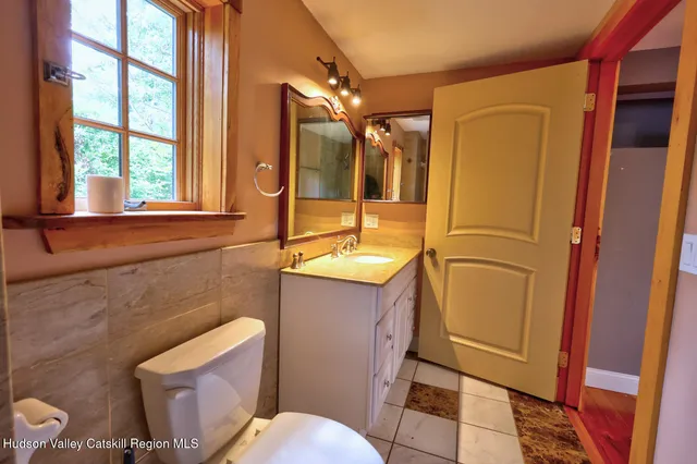 a bathroom with a sink a toilet a mirror and shower