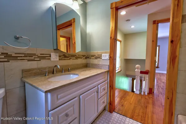 a bathroom with a granite countertop sink and a mirror