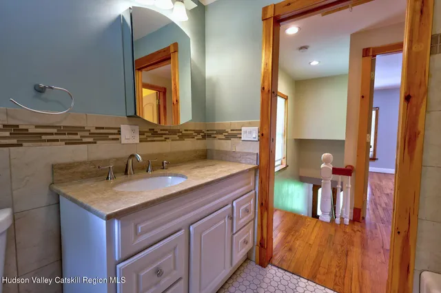 a bathroom with a granite countertop sink and a mirror