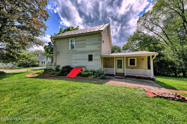 a view of a house with backyard and sitting area