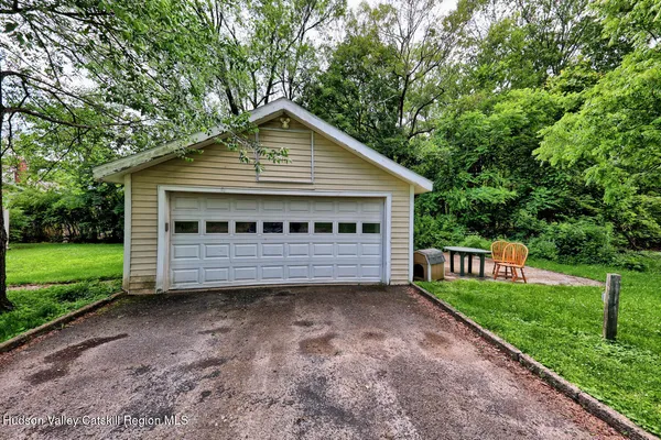 a view of a house with a yard plants and large tree