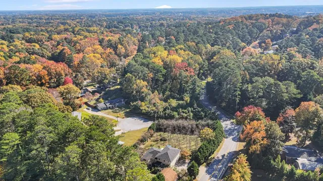 an aerial view of a houses with a yard and lake view