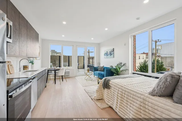 a living room with stainless steel appliances kitchen island granite countertop furniture and a couch