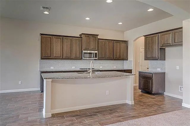 20008 Navarre Terrace Pflugerville, TX 78660 - Photo 2 of 18 a kitchen with stainless steel appliances granite countertop a sink stove and microwave