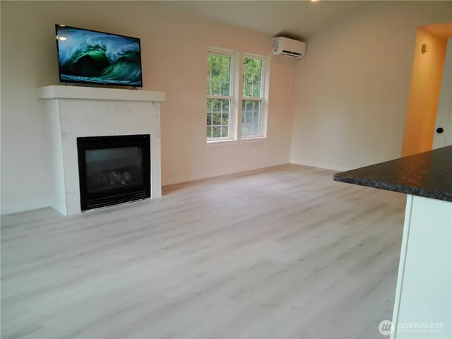 a view of an empty room with a fireplace and a window