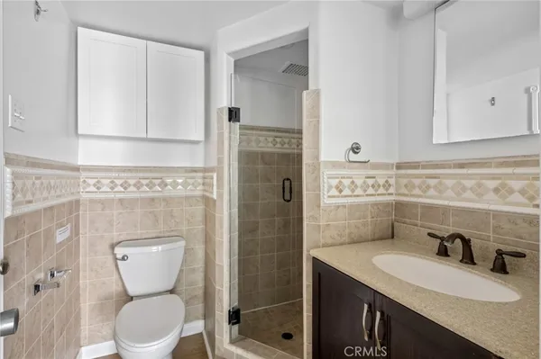a bathroom with a granite countertop toilet sink and mirror