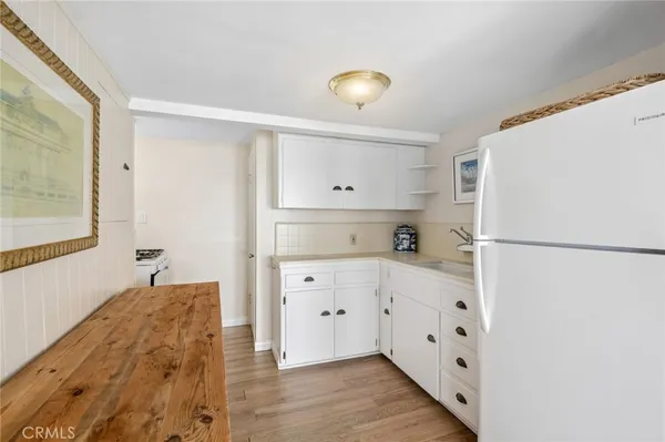 a kitchen with white cabinets and refrigerator
