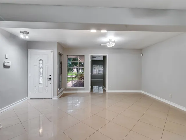a view of an empty room and kitchen view