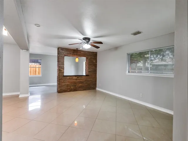 a view of a livingroom with a ceiling fan and window