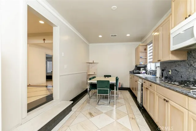 a kitchen with a sink and chairs