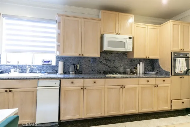 a kitchen with white cabinets sink and window