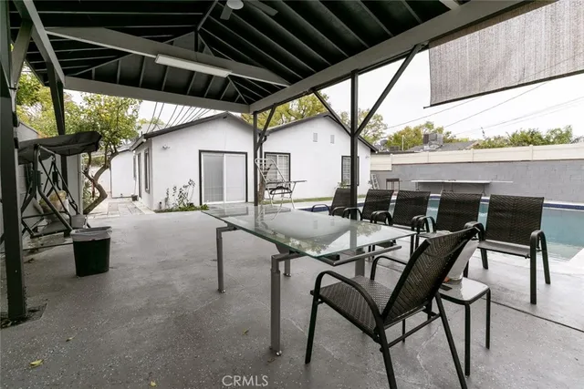 a view of a patio with table and chairs and potted plants
