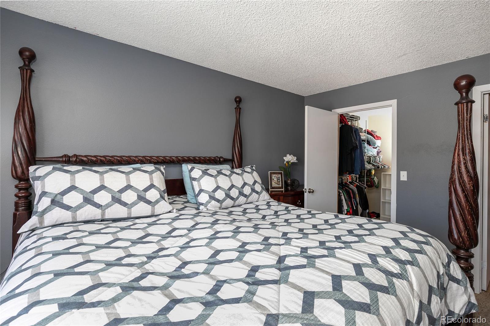 8741 Dawson Street, Unit 304 Denver, CO 80229 - Photo 20 of 27 a large bed in a bedroom and a mirror
