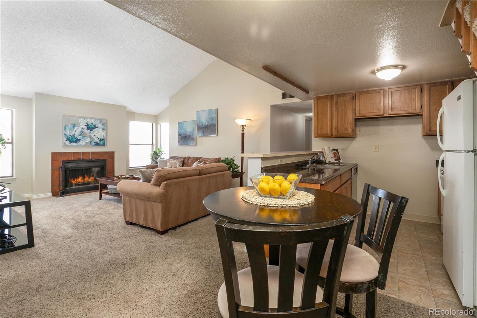 8741 Dawson Street, Unit 304 Denver, CO 80229 - Photo 2 of 27 a living room with furniture a fireplace and a dining table