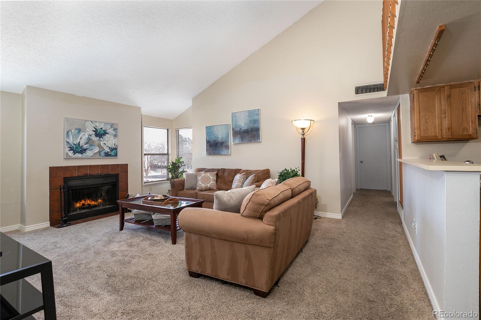 8741 Dawson Street, Unit 304 Denver, CO 80229 - Photo 3 of 27 a living room with furniture and a fireplace