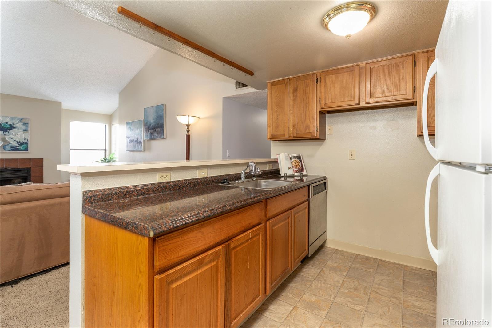 8741 Dawson Street, Unit 304 Denver, CO 80229 - Photo 10 of 27 a kitchen with stainless steel appliances granite countertop a sink stove and refrigerator