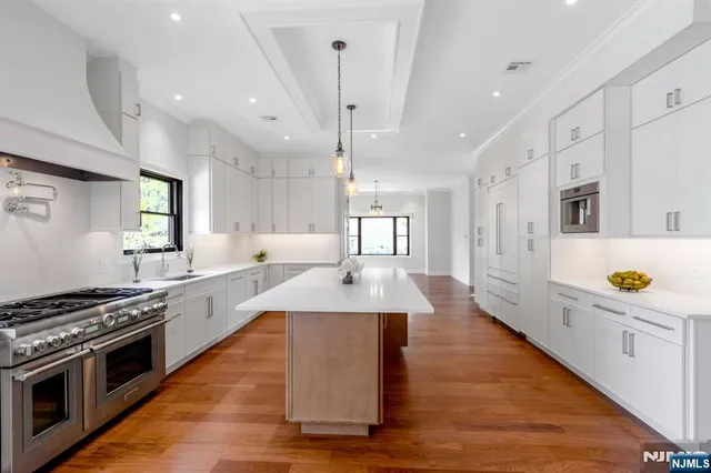 a large kitchen with stainless steel appliances granite countertop a lot of counter space and wooden floor