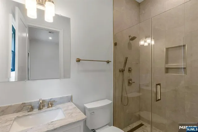 a bathroom with a granite countertop sink toilet and shower