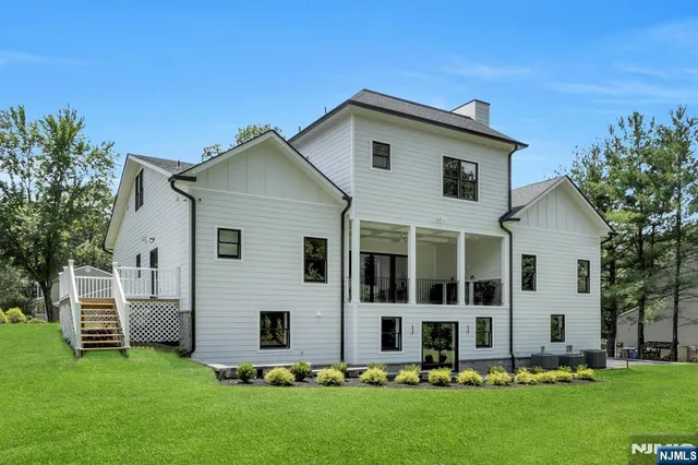 a view of brick house with large windows and potted plants