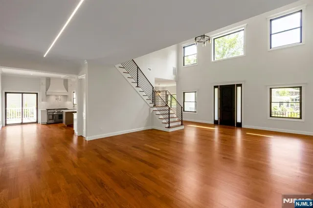 a view of empty room with wooden floor and stairs