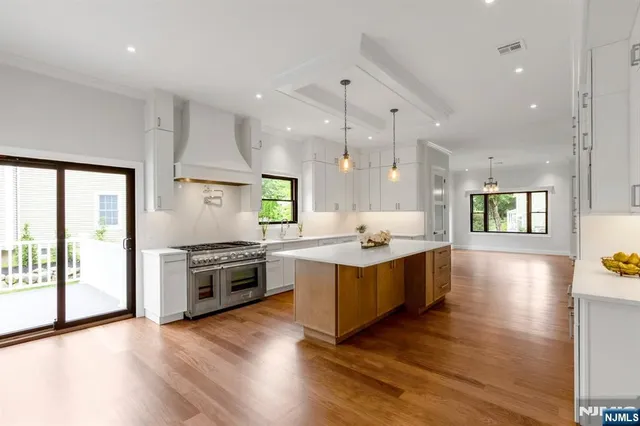 a large kitchen with wooden floors and stainless steel appliances