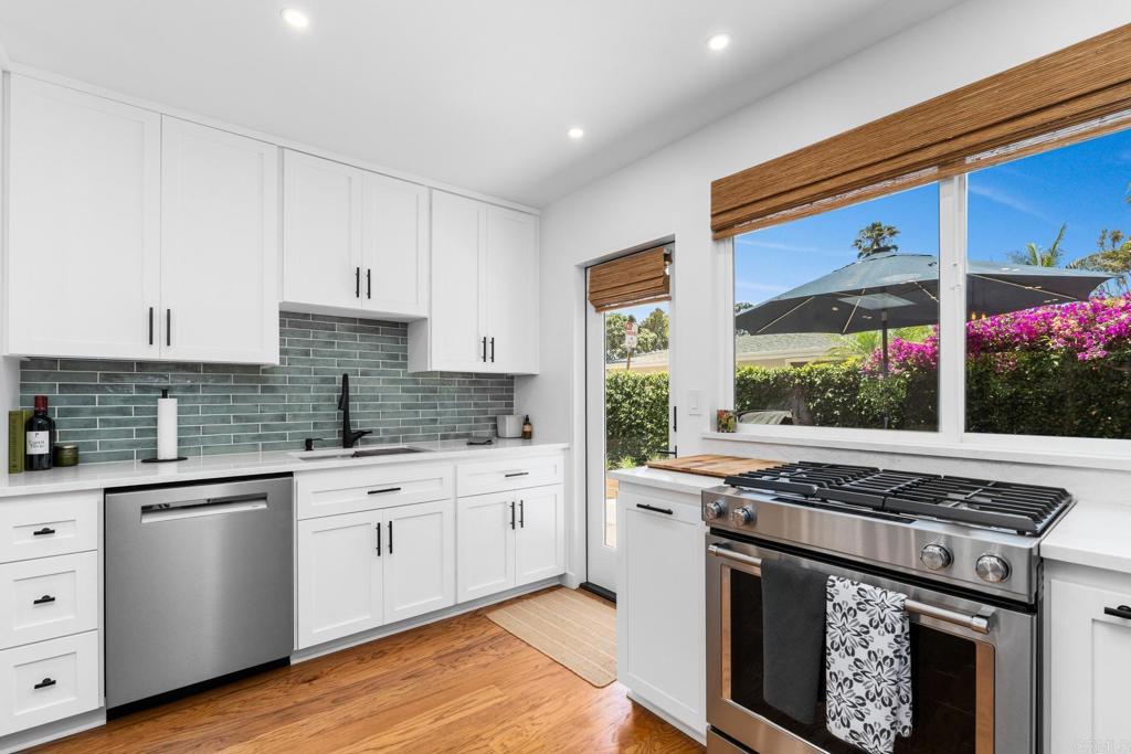 219 24th Street Del Mar, CA 92014 - Photo 5 of 15 a kitchen with stainless steel appliances granite countertop a stove a sink and white cabinets
