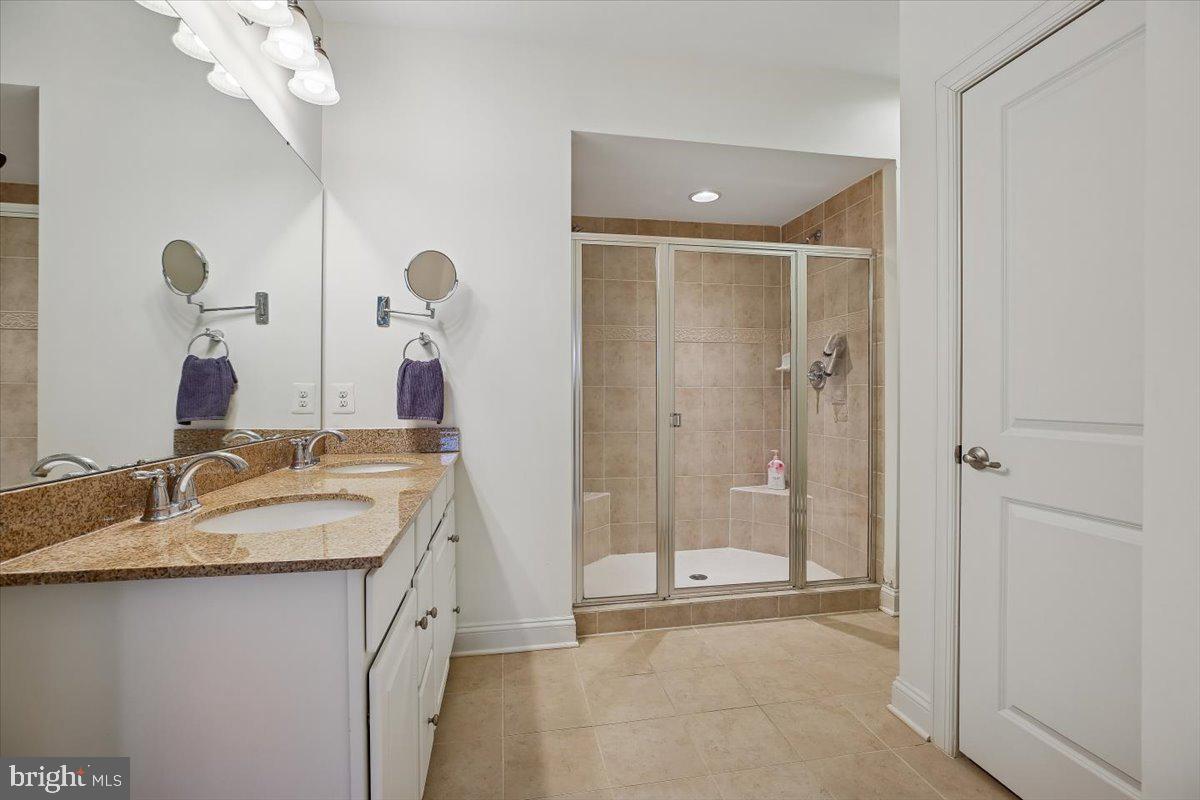 452 Exchange Avenue Gaithersburg, MD 20878 - Photo 12 of 37 a bathroom with a granite countertop sink a mirror and a shower
