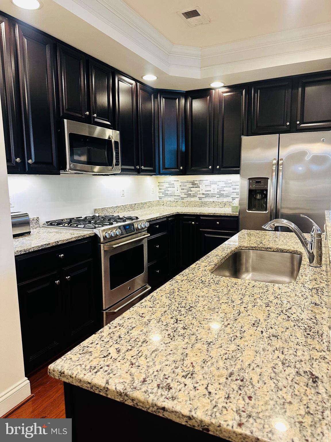 452 Exchange Avenue Gaithersburg, MD 20878 - Photo 7 of 37 a kitchen with stainless steel appliances kitchen island granite countertop a sink stove and refrigerator