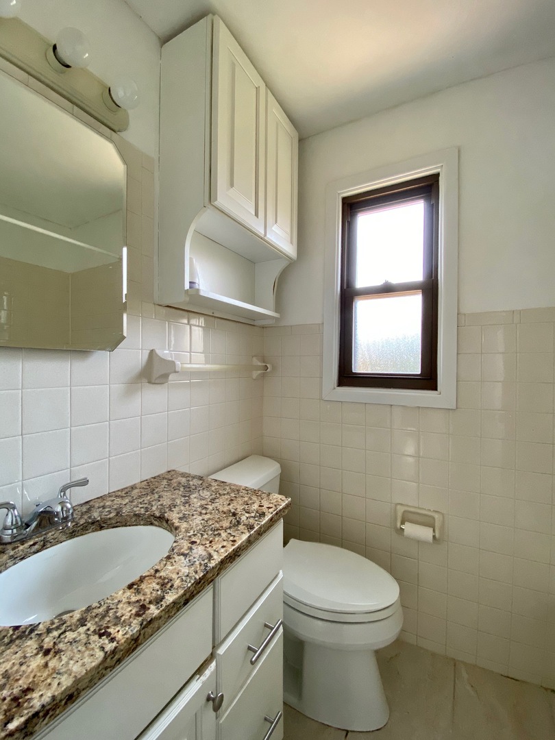 511 Ridge Road, Unit 511 Wilmette, IL 60091 - Photo 9 of 14 a bathroom with a granite countertop toilet sink and mirror