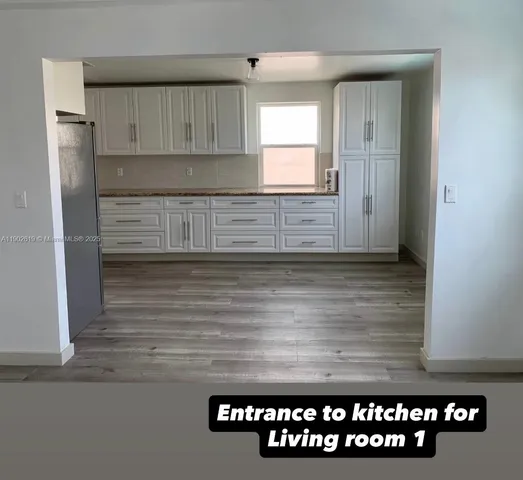 a kitchen with granite countertop a refrigerator and a stove top oven