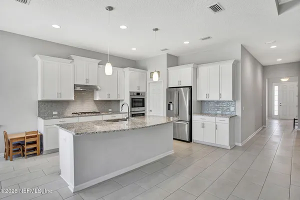 a kitchen with kitchen island granite countertop a sink a stove and cabinets