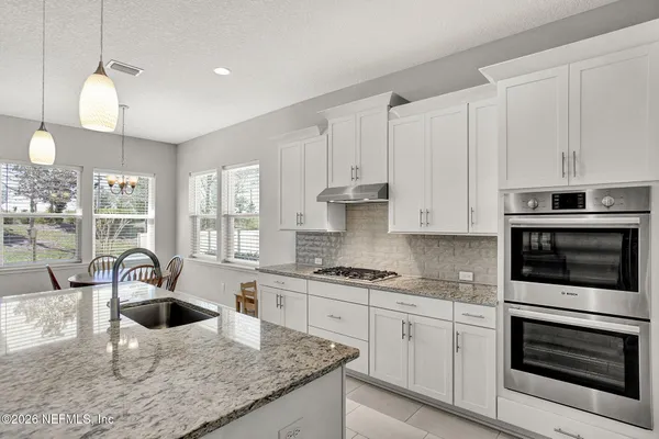 a kitchen with a table chairs and a sink