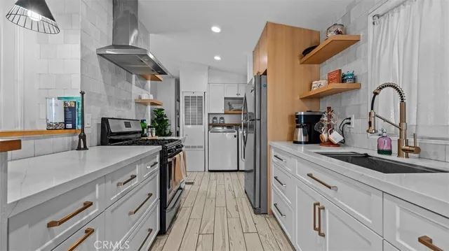a kitchen with kitchen island a sink appliances cabinets and a counter top space