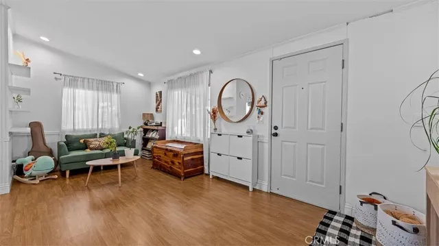 a living room with furniture a wooden floor and a large window