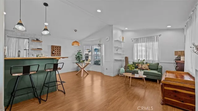 a living room with furniture a wooden floor and a chandelier