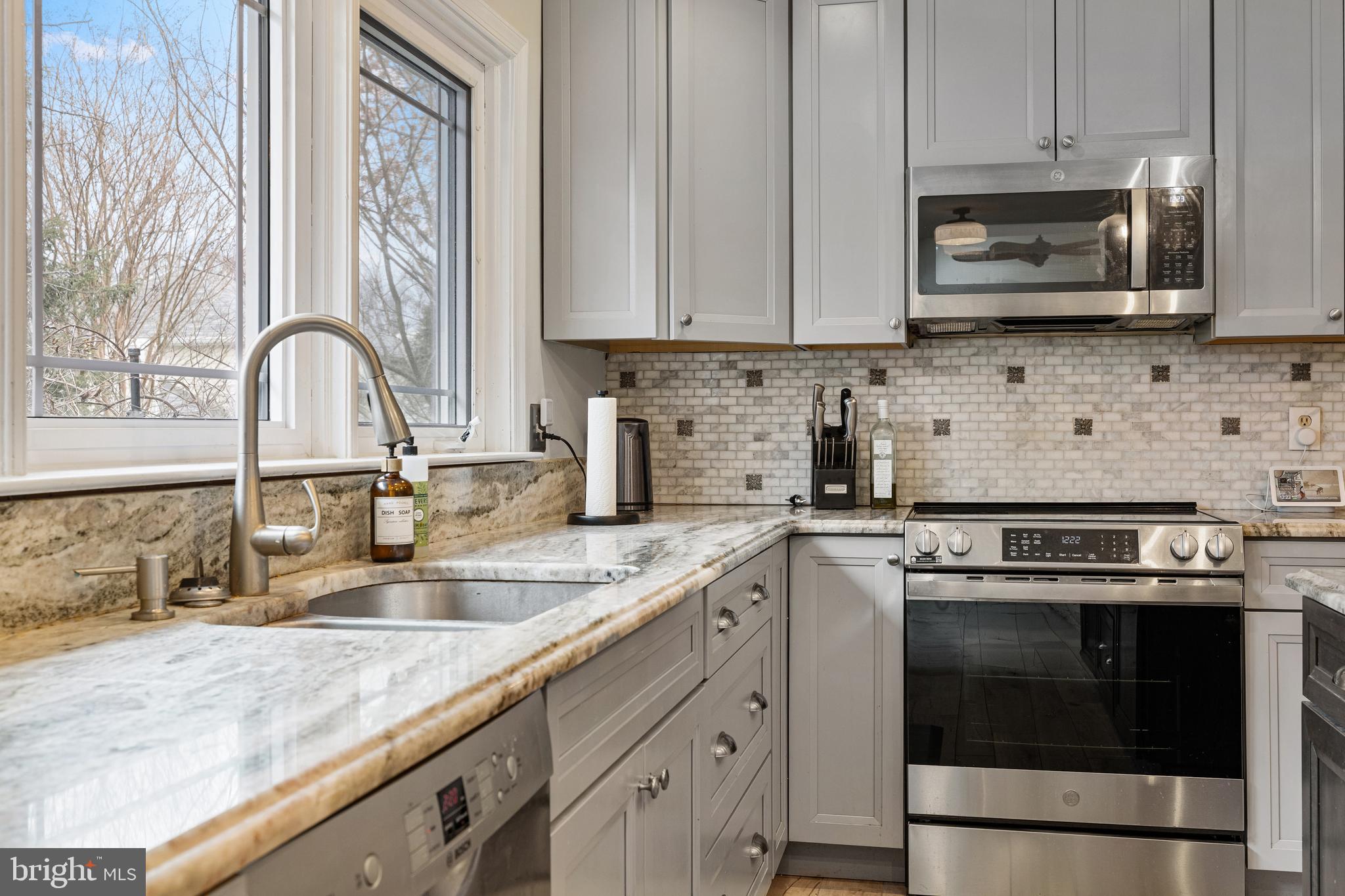 1439 Millikens Bend Road Herndon, VA 20170 - Photo 43 of 46 a kitchen with granite countertop white cabinets and stainless steel appliances