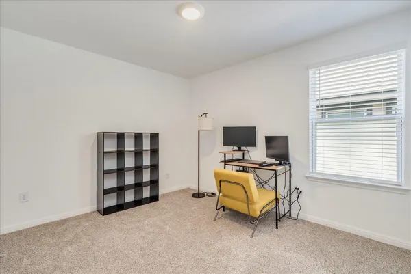 a view of a livingroom with workspace and a window