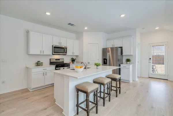 a kitchen with white cabinets and stainless steel appliances