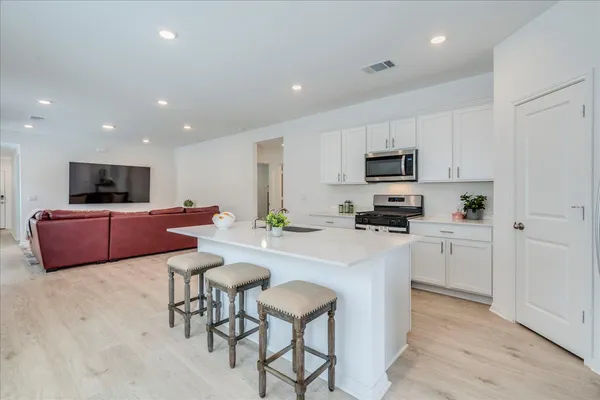 a kitchen with table chairs microwave and cabinets