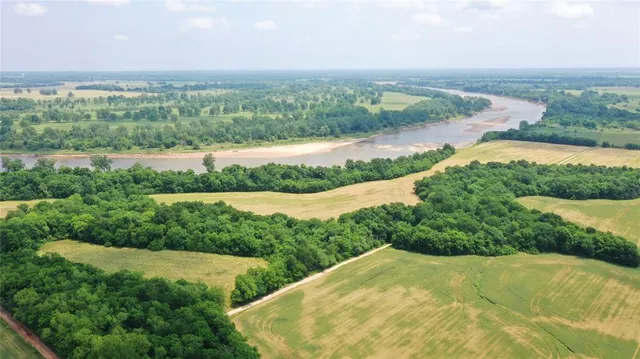an aerial view of ocean with green space