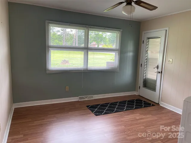 a view of a room with wooden floor and windows