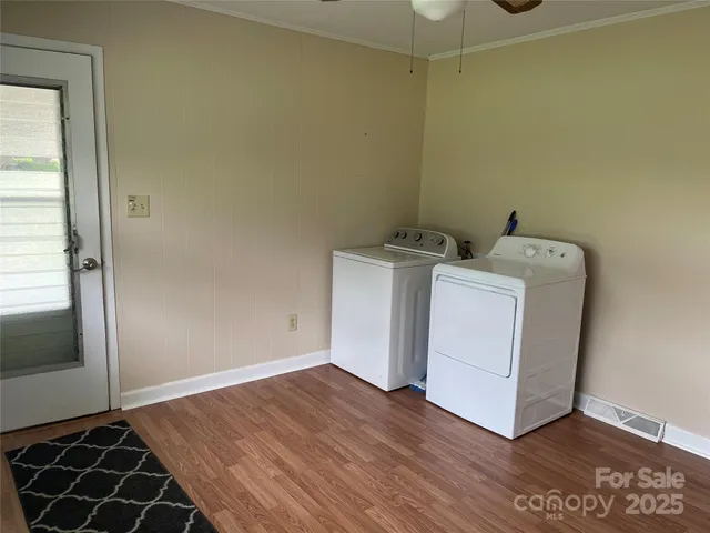 a utility room with wooden floor washer and dryer